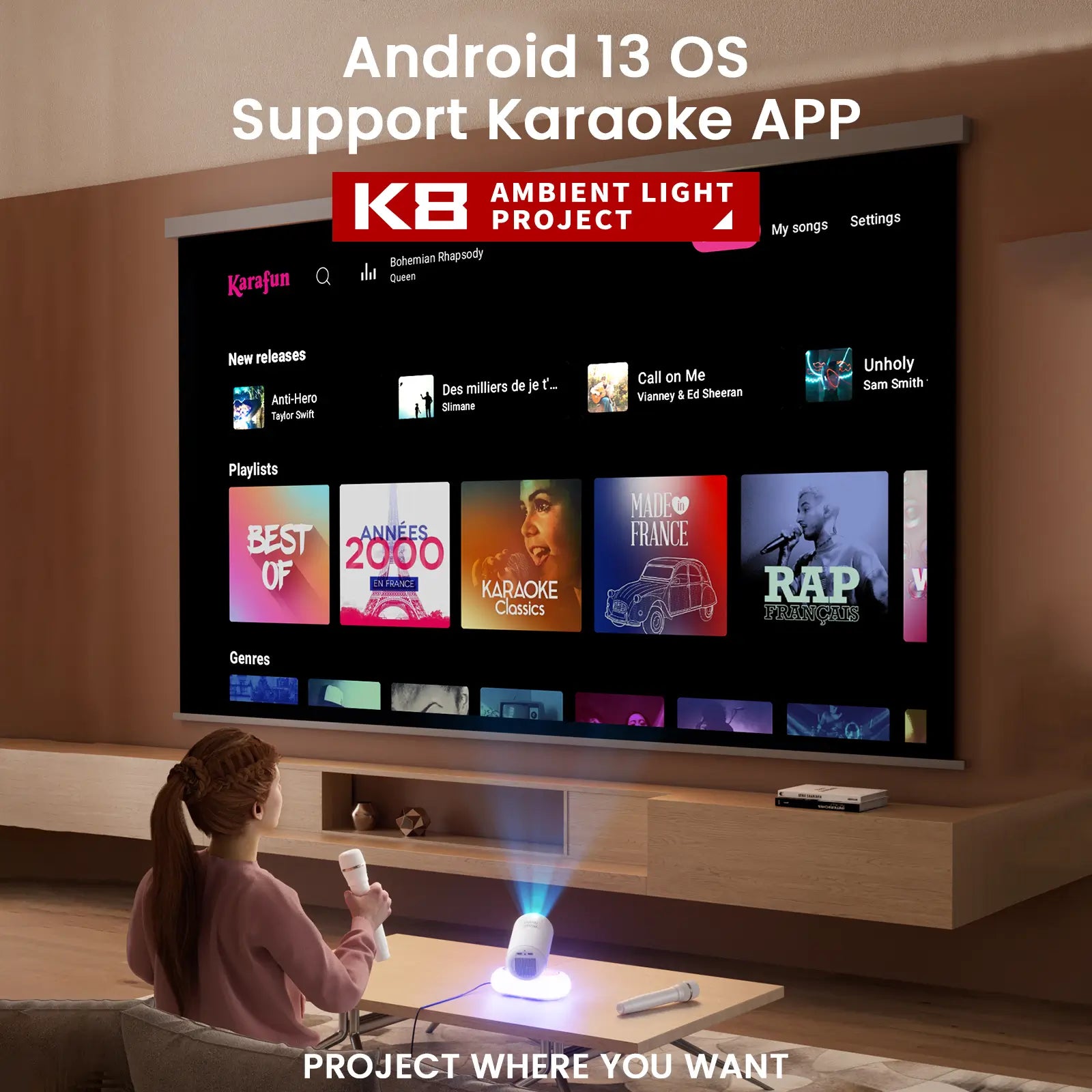 A user holding a microphone, ready to sing with the Geitepor K8 projector, which is displaying a karaoke app interface on a large screen, showing its built-in Android 13 OS capabilities.