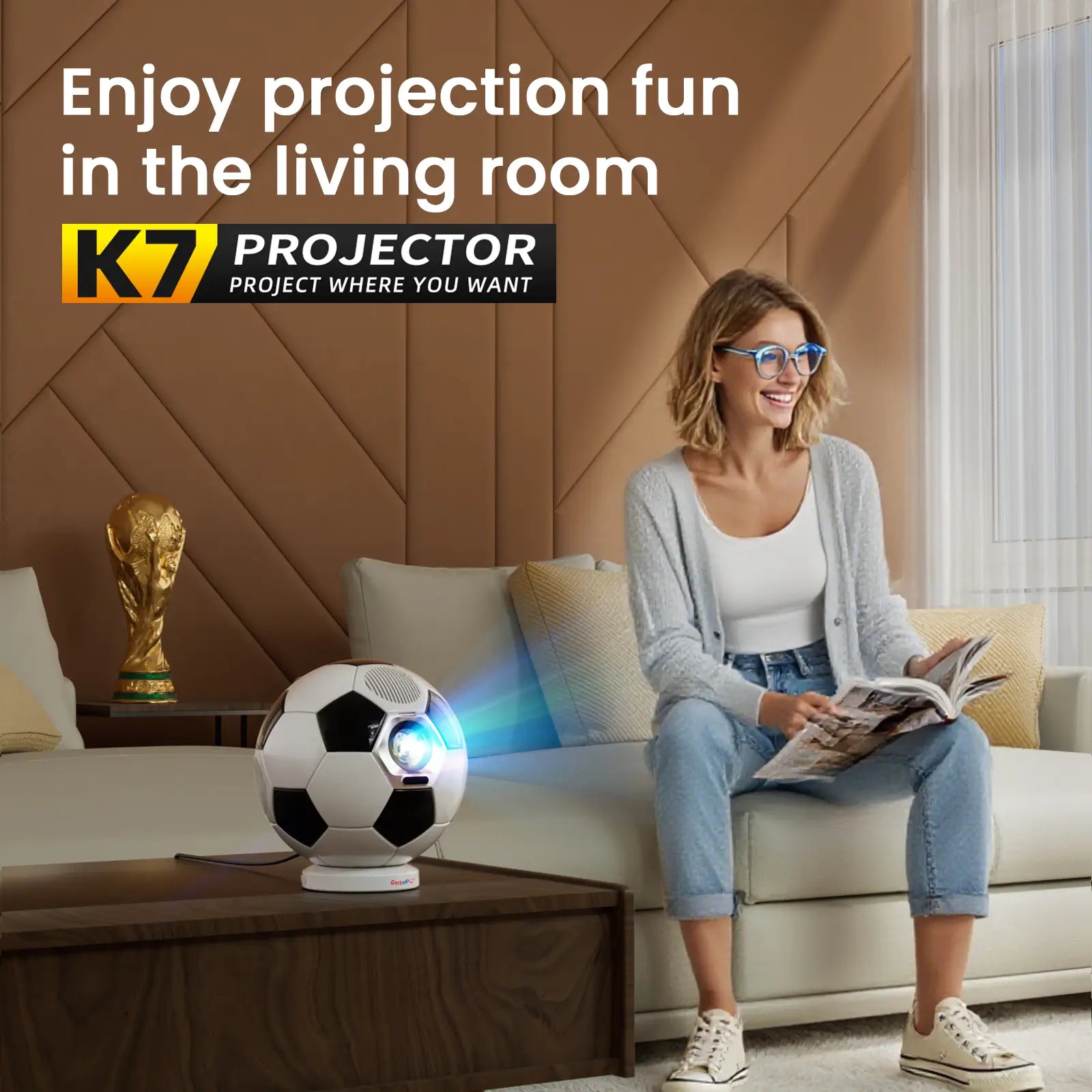 A woman relaxes in her modern living room with the stylish, soccer-ball-shaped K7 projector on the coffee table.